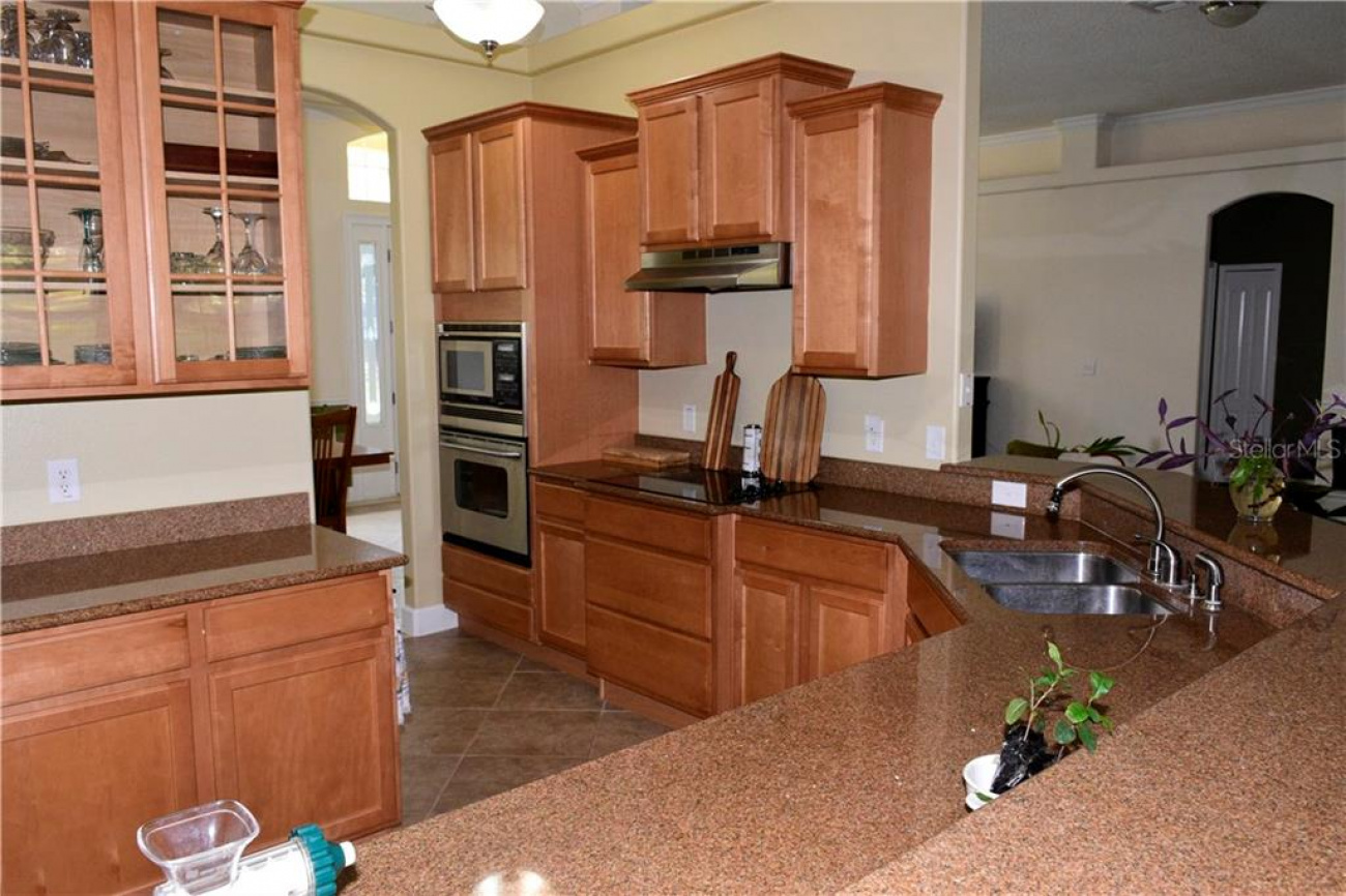 Granite countertops throughout the kitchen with stainless steel appliances to include microwave, oven and a side by side refrigerator and plenty of cabinets.