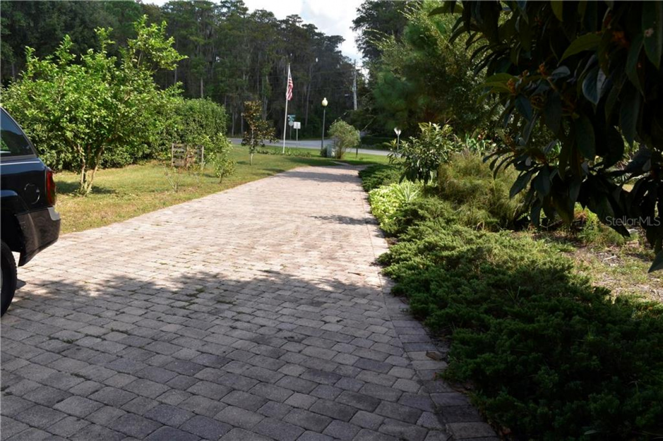 This is a brick paved driveway that will lead you to the home surrounded by beautiful mature landscaping throughout the property.