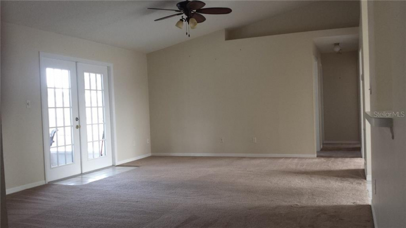 Spacious living room / dining room combo area with ceiling fans and plant shelves throughout.