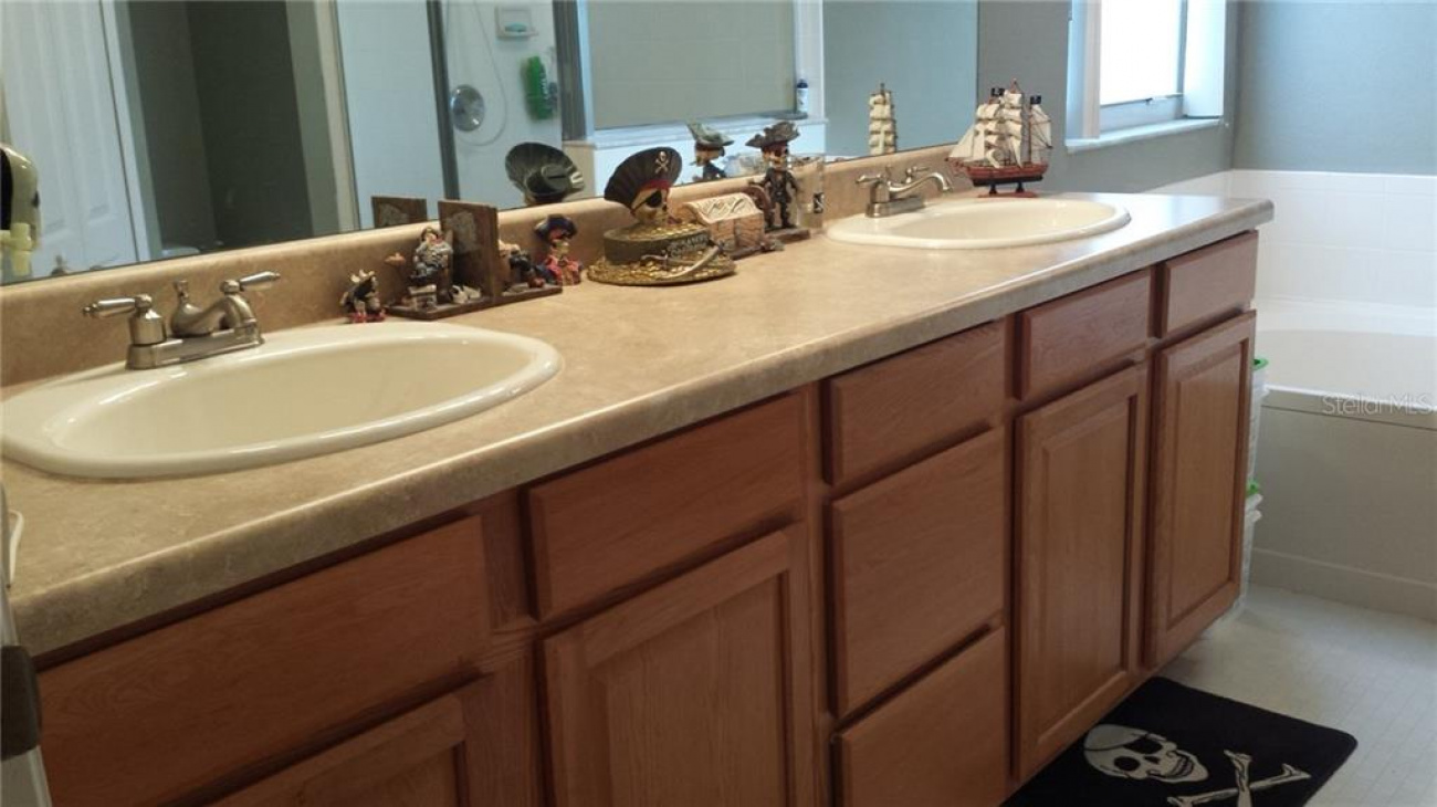 Upgraded cabinetry in master bathroom with dual sinks and oversized mirror.